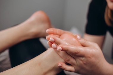 Güzellik salonunda ayak masajı yaptıran genç bir kadın.