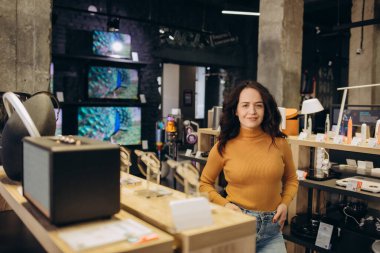 Elektronik mağazasındaki kıvırcık saçlı kadın..