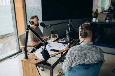 Radyo için canlı programı ılımlı yapan iki radyo sunucusu.