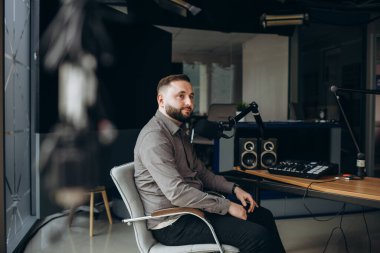 Radyo istasyonunda radyo sunucusu olarak çalışan mutlu genç adamın portresi..