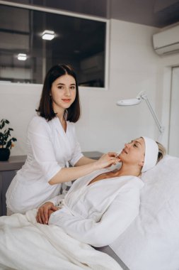 Doktor kozmetik uzmanı güzellik salonunda güzel bir kadının dudak büyütme ameliyatını yapıyor. Prp terapisi, kırışıklık önleyici ve yaşlanan cilt. Kozmetoloji cilt bakımı.