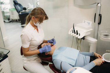 Dişçi ve hasta muayenehanesinde.