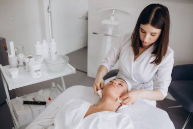 Kozmetik uzmanı, güzellik salonunda bir hastası olan bir profesyonel..