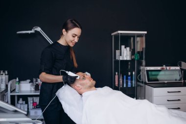 Güzellik Salonu geçiren microcurrent terapi genç adam.