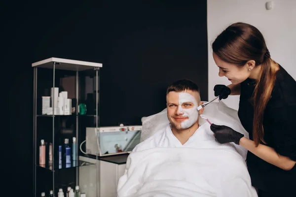 Cosmetologist Aplicando Uma Máscara Barro Rosto Masculino Tratamento Spa Cuidados — Fotografia de Stock