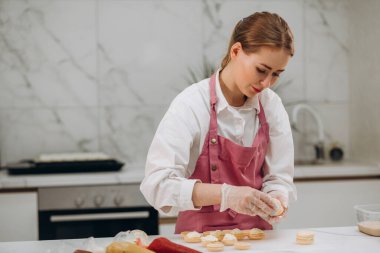 Yemek, pişirme ve insanlar kavramı - parşömen kağıt pasta dükkanı mutfak at macaron meyilli veya beze krema sıkma şekerlemeler çantalı Şef.