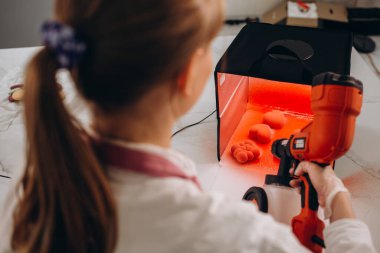 Pastanın yüzeyine sprey tabancalı pasta şefi ile sıcak çikolata tablosu uygular.