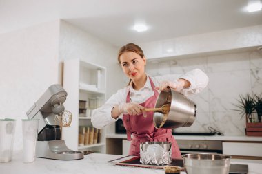 Bir kadın mutfakta cheesecake hazırlıyor..