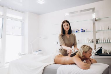 Hardware figure correction with vacuum her back massage. Overweight treatment, body sculpting.