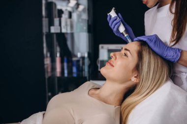 Woman getting a facial dermapen treatment at spa salon. Beauty concept. Face cosmetic procedure. Cosmetology. Skin Lift Procedure.