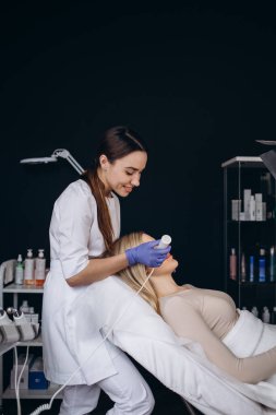 Modern kozmetik kliniğinde yetişkin kadınlar için fonoforez yüz prosedürü