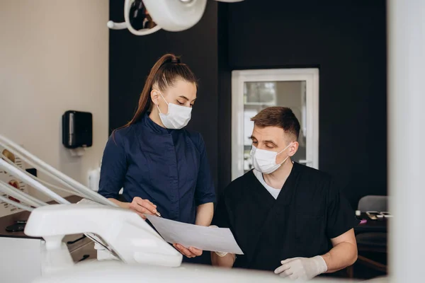 Dentysta Jego Asystent Rozmawiają Aktach Pacjenta — Zdjęcie stockowe