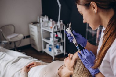 Kozmetik uzmanının spa merkezinde gençleşmek için yüzüne dermapen enjekte ettiği bir iğne..