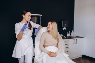 Bir güzellik uzmanı ve bir hastanın portresi. Kırışıklık enjeksiyonu.