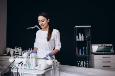 Kuaförde masaj aleti kullanan kadın güzellik uzmanının portresi. Güzellik salonunda kozmetik uzmanı. Güzellik kliniğinde kozmetolog dermatolog. Yüz bakımı. Kozmetik prosedürleri