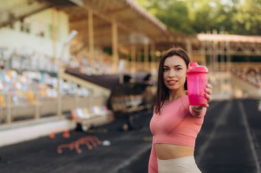 Koşu, sağlık ve spor konseptinden sonra su içen Asyalı genç kadın.