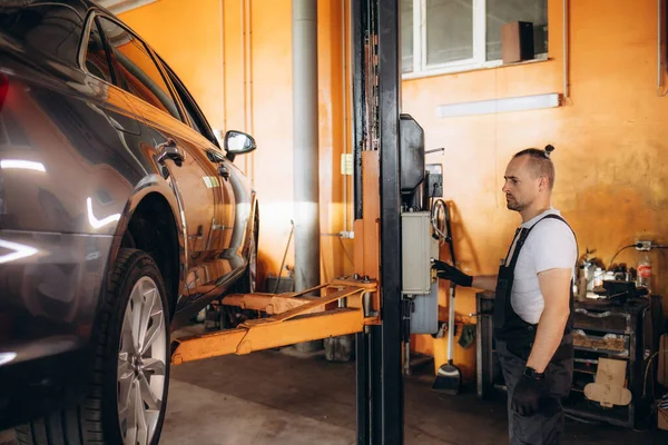 車メカニック スパナで締めリフト自動車修理サービス ステーションでの車のサスペンション詳細 — ストック写真