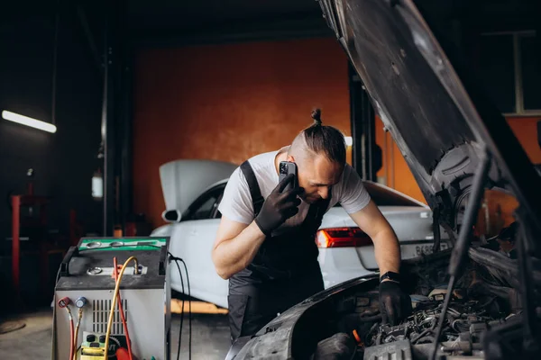 Otomobil Tamircisi Oto Tamirhanesinde Cep Telefonuyla Konuşuyor — Stok fotoğraf