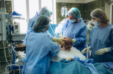 Doktor ve hemşire annemin karnından yeni doğmuş bir bebek çıkarıyorlar..