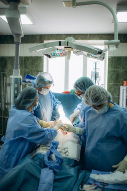 Ameliyat ekibi cerrahi işlemi gerçekleştirerek. Cerrahi kullanarak gerçekleştirme doktor ekipman sterilize. Jinekologlar ve doğum ebe. Bebek Hamile hastanede.
