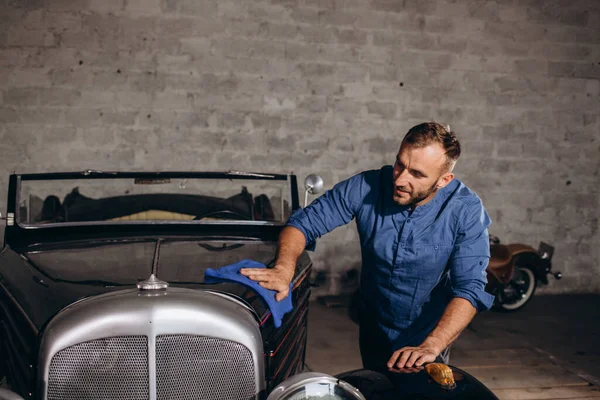 中年の男性がガレージでレトロな車を拭き取り — ストック写真