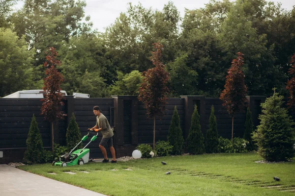 Hombre Está Trabajando Jardín Cortando Hierba Con Una Cortadora Césped — Foto de Stock
