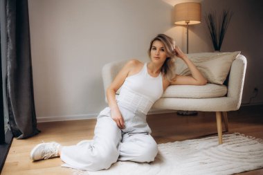 Kanepenin yanında oturan genç kadın.