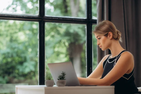 Красива Молода Жінка Працює Ноутбуком Затишному Дивані Біля Великого Вікна — стокове фото