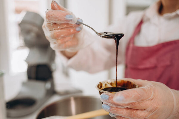 кулинарные, выпечки и приготовления пищи концепции - счастливая улыбающаяся молодая женщина делает слоистый торт на кухне дома