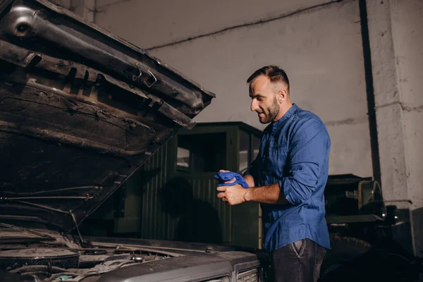 男はガレージでレトロ車を修理する — ストック写真