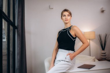 Kendine güvenen iş kadını deftere yazıyor, çalışma masasında, ev ofisinde duruyor, genç bayan planlama günü, organizatördeki toplantılar, öğrenci defterinde notlar tutuyor, web sitesi seyrediyor, ders veriyor.