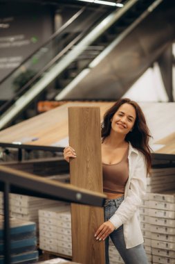 İnşaat mağazasının zemin kaplamalı deposunda, yansıtıcı müşteri bu mağazadan kaplama döşeme satın almayı düşünüyor. Yüksek kalite fotoğraf