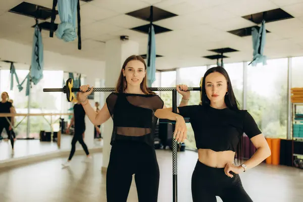 two women do fitness with barbells. fitness trainer.