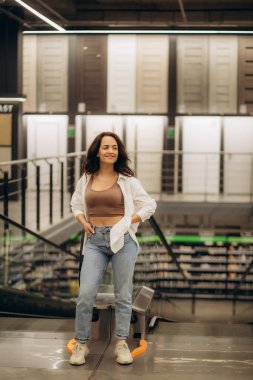 Kadın mağazadaki yürüyen merdivene tırmanıyor..