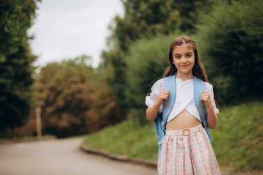 Sırt çantalı küçük bir kız okula gidiyor. Mesaj için yer var. Yüksek kalite fotoğraf