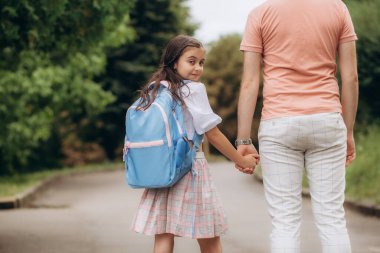 Küçük kız ilkokula gidiyor. Sırt çantalı çocuk ders çalışacak. Okul konseptine geri dönelim. Yüksek kalite fotoğraf