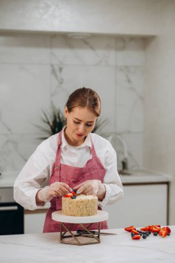 Mutfakta çikolatalı pasta süsleyen bir kadın. Kadın aşçı evde pasta yapıyor. Yüksek kalite fotoğraf