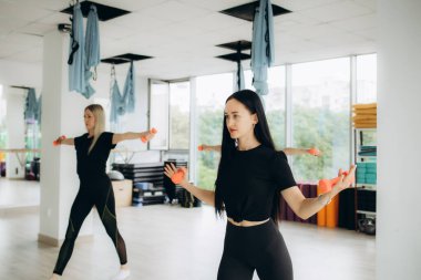 Fitness, spor, antrenman, spor salonu ve yaşam tarzı konsepti. Spor salonunun arka tarafındaki halterlerle çalışan bir grup insan. Yüksek kalite fotoğraf