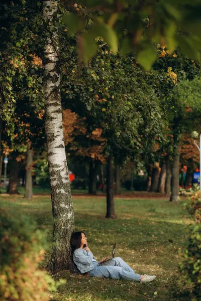 Sakin bir iş kadını dışarıda Lotus 'ta meditasyon yapıyor, barışçıl kadın serbest çalışan ofiste yoğun bir iş gününden sonra parkta oturmuş, el ele tutuşurken yoga egzersizleri yapıyor. Yüksek kalite fotoğraf