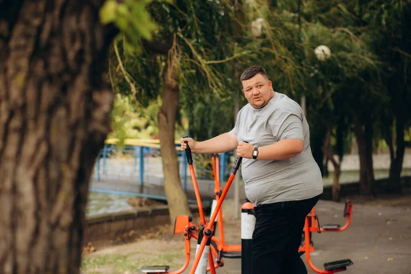a fat man loses weight on an exercise bike
