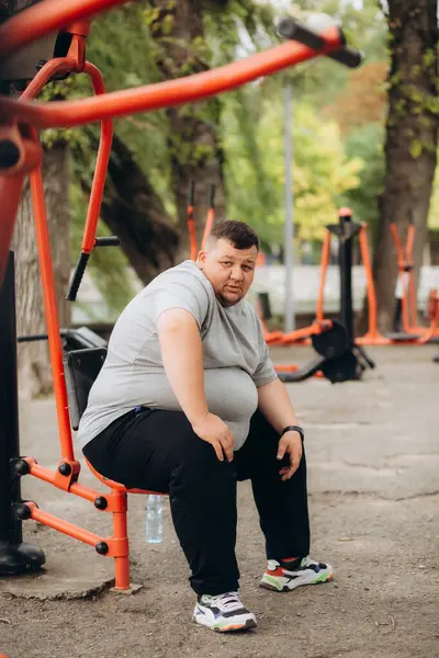 a fat man rests after sports in the fresh air