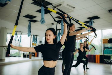 Genç ve mutlu bayan sporcu, sağlık kulübünde egzersiz sınıfında bir grup kadınla ısınıyor. Yüksek kalite fotoğraf