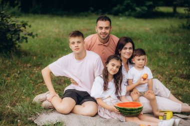 Karpuz, aşk ya da büyük aile Berlin 'de yaz tatilinde sağlıklı meyve ya da yiyecek yemek pikniğinde. Büyükbaba, anne ve baba, çocuklarla bağ kurmaktan ya da rahatlamaktan hoşlanırlar. Yüksek kalite fotoğraf