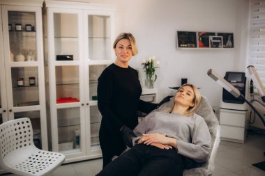 Profesyonel makyaj sanatçısı ve müşterisi dudak kızarma işlemi sırasında. Yüksek kalite fotoğraf