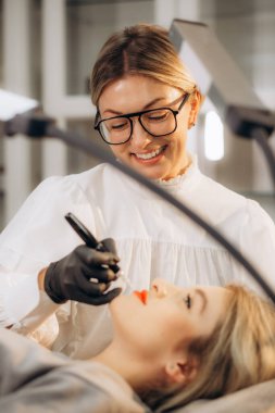 Profesyonel makyaj sanatçısı ve müşterisi dudak kızarma işlemi sırasında. 