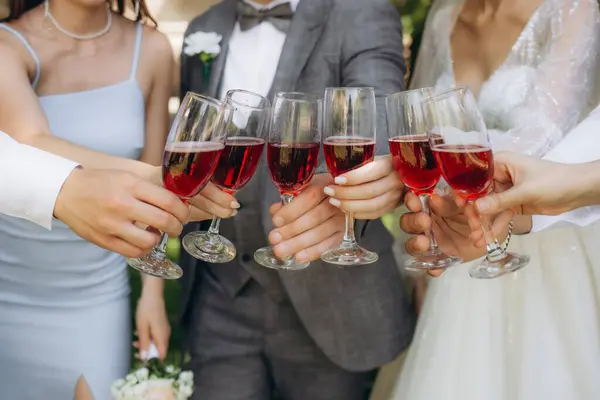 Cheers! People celebrate and raise glasses of wine for toast. Group of man and woman cheering with champagne. High quality photo