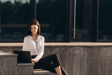 Modern bina arka planında çalışan gülümseyen kadın yöneticiye yakın plan. Yüksek kalite fotoğraf
