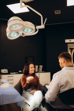 Caucasian woman and plastic surgeon touching and choosing breast implants. 