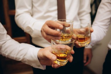 Partide kadeh tokuşturup arkadaşlarıyla buluşan insanların ellerini kapat. Kutlama, parti alkol konsepti. Yüksek kalite fotoğraf