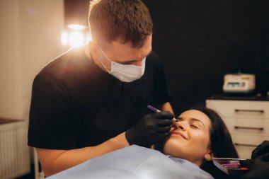 Klinikte estetik cerrah hastanın yüzüne izler sürüyor. Yüksek kalite fotoğraf